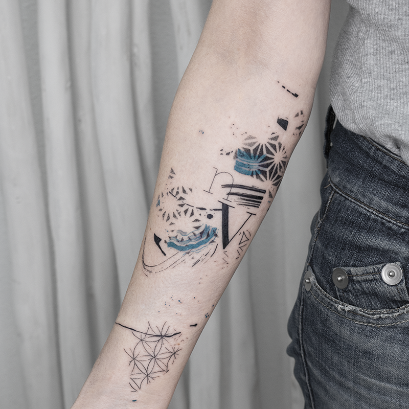 Tattoo en el antebrazo con la palabra geometría azul letras de Leire Mdmi en Asanoha Tattoo Studio